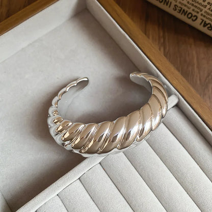 Silver bangle on a soft surface with a wooden background