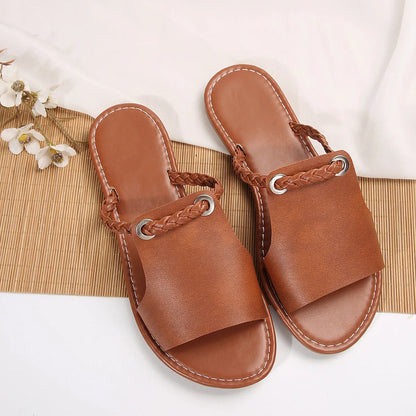 Pair of brown sandals with braided straps on a white background