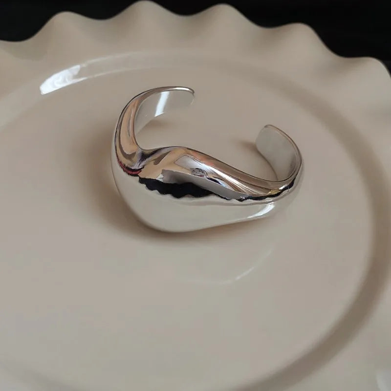 Silver open ring on a beige plate