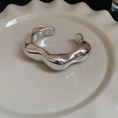 Silver bracelet on a beige ceramic plate
