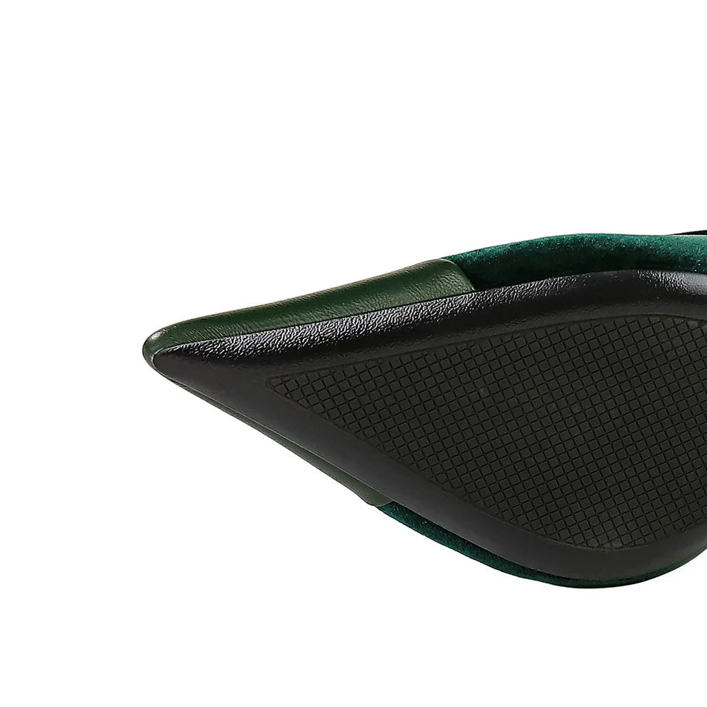 Close-up of a green and black shoe with textured sole on a white background