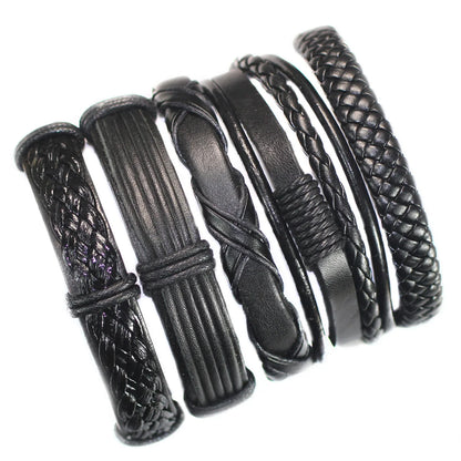 Set of black leather bracelets with braided and textured designs on a white background