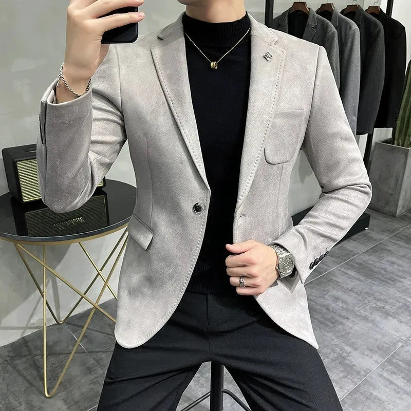 Person wearing a light gray blazer over a black shirt in a clothing store.