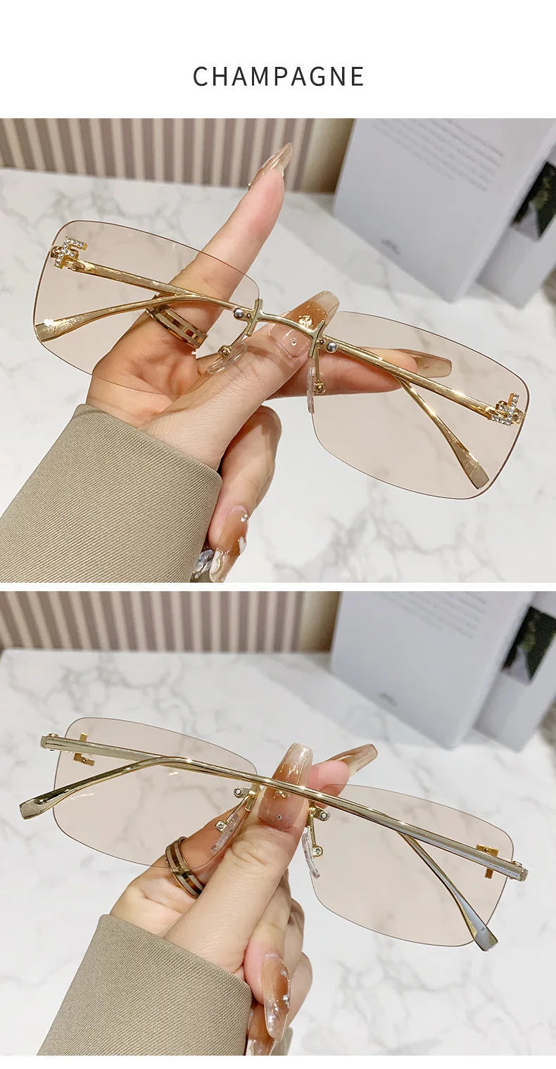 Transparent sunglasses with gold frames held by a hand on a light background