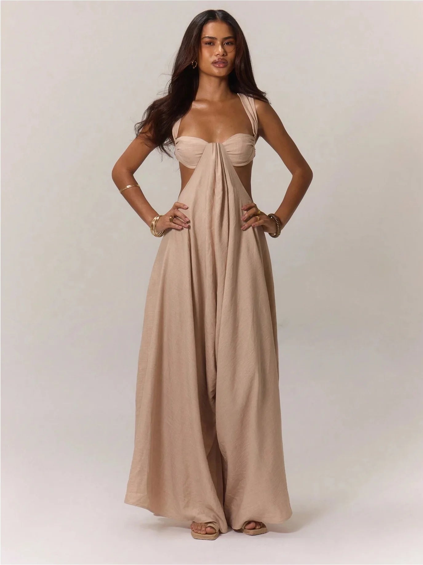 Woman wearing a beige evening gown on a plain background
