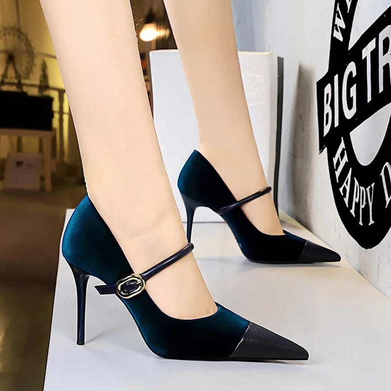 Teal high-heeled shoes with a strap worn by a person indoors.