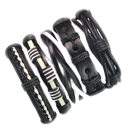 Set of black leather bracelets with various patterns on a white background