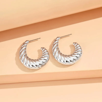 Silver hoop earrings on a peach-colored background