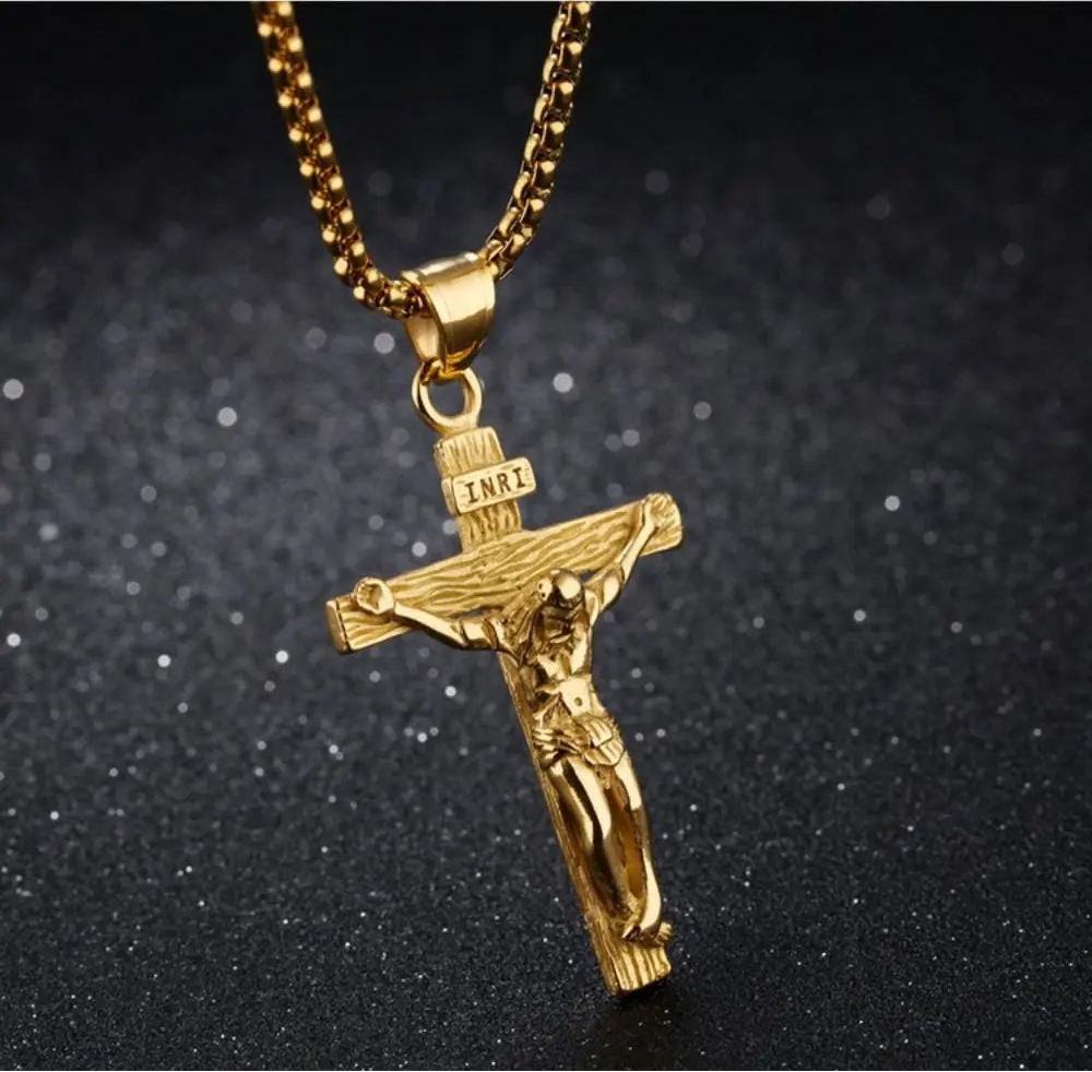 Gold crucifix pendant necklace on a dark background
