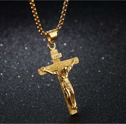 Gold crucifix pendant necklace on a dark background