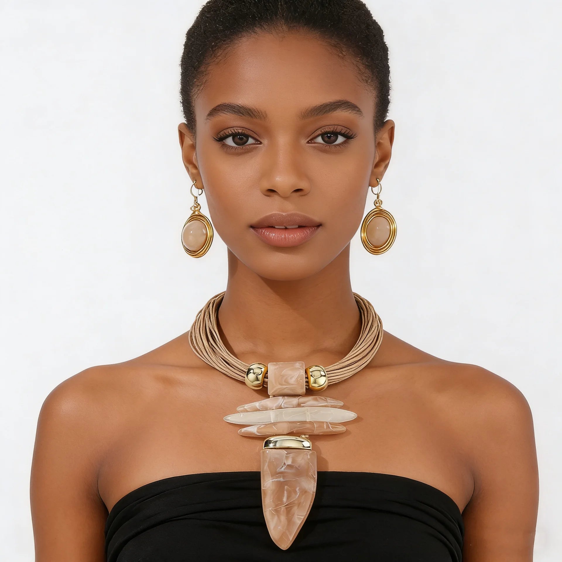 Woman wearing a necklace and earrings with a plain background