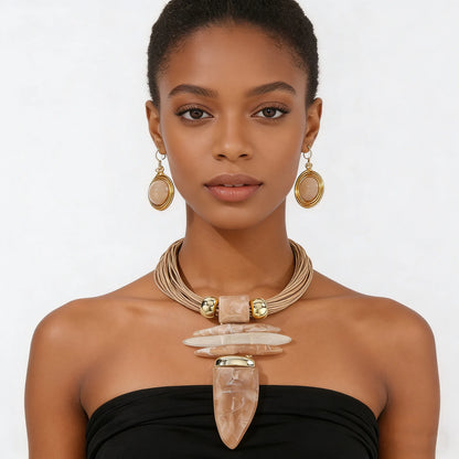 Woman wearing a necklace and earrings with a plain background