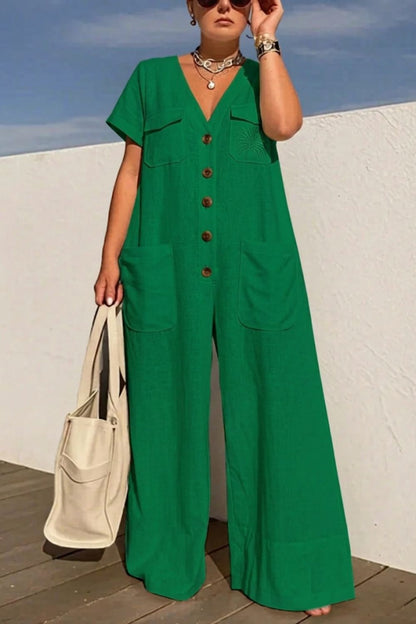 Person wearing a green jumpsuit with a white wall and blue sky in the background