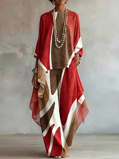 A woman models a loose, bohemian-style two-piece outfit featuring a rust red, brown, and white abstract patterned top and matching wide-leg pants, styled with layered pearl necklaces and bracelets against a neutral gray background.