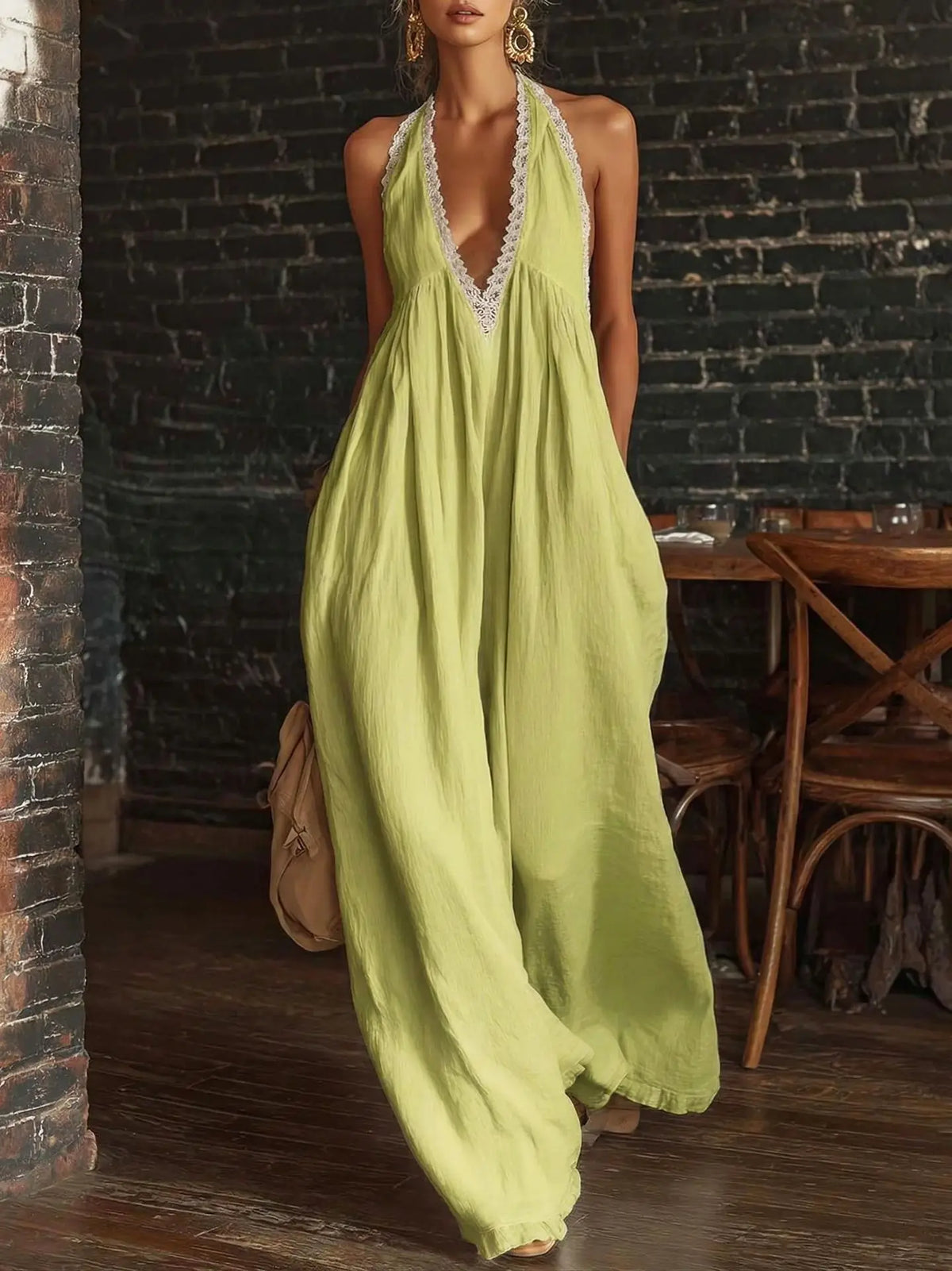 Woman wearing a light green halter neck dress in an indoor setting with wooden furniture.