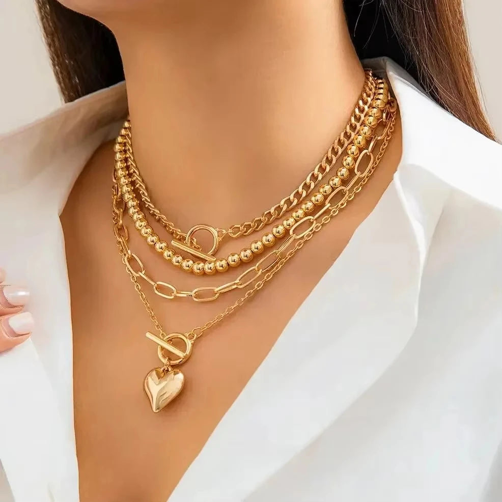 Gold necklaces with heart pendant on a white background