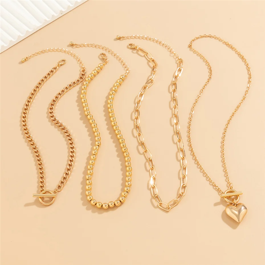 Four gold necklaces on a beige background