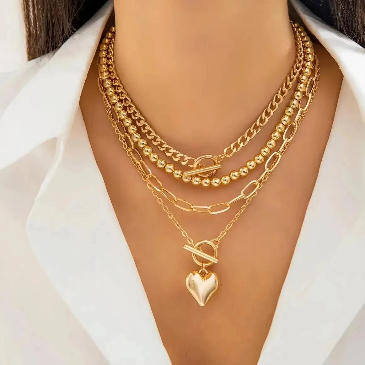 Gold necklaces with a heart pendant on a mannequin