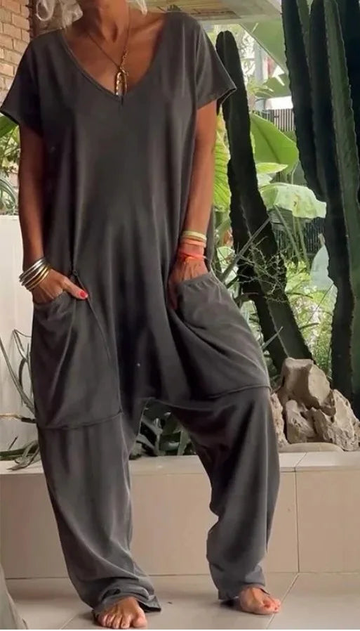 Person wearing a gray oversized outfit with wide-leg pants and a t-shirt, standing outdoors.