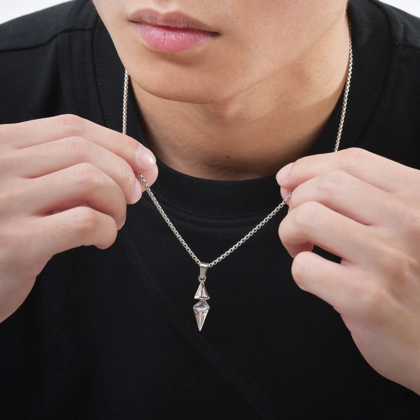 Gold arrow spike necklace worn by male model in black t-shirt outdoors
