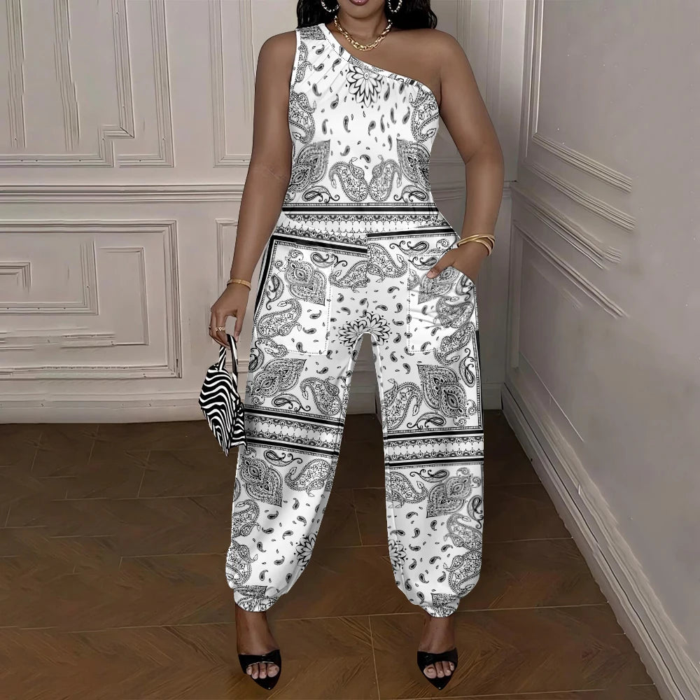 Woman wearing a white and black patterned jumpsuit in a room with wooden flooring and white walls.