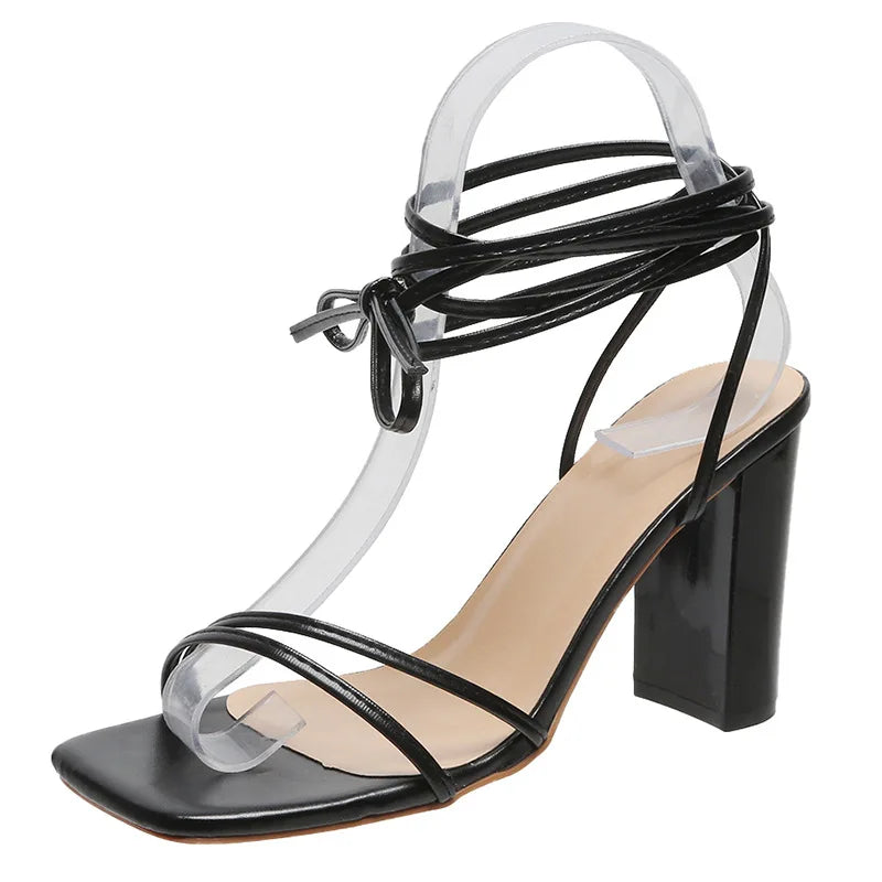 Black block heel sandals showing square heel and buckle closure