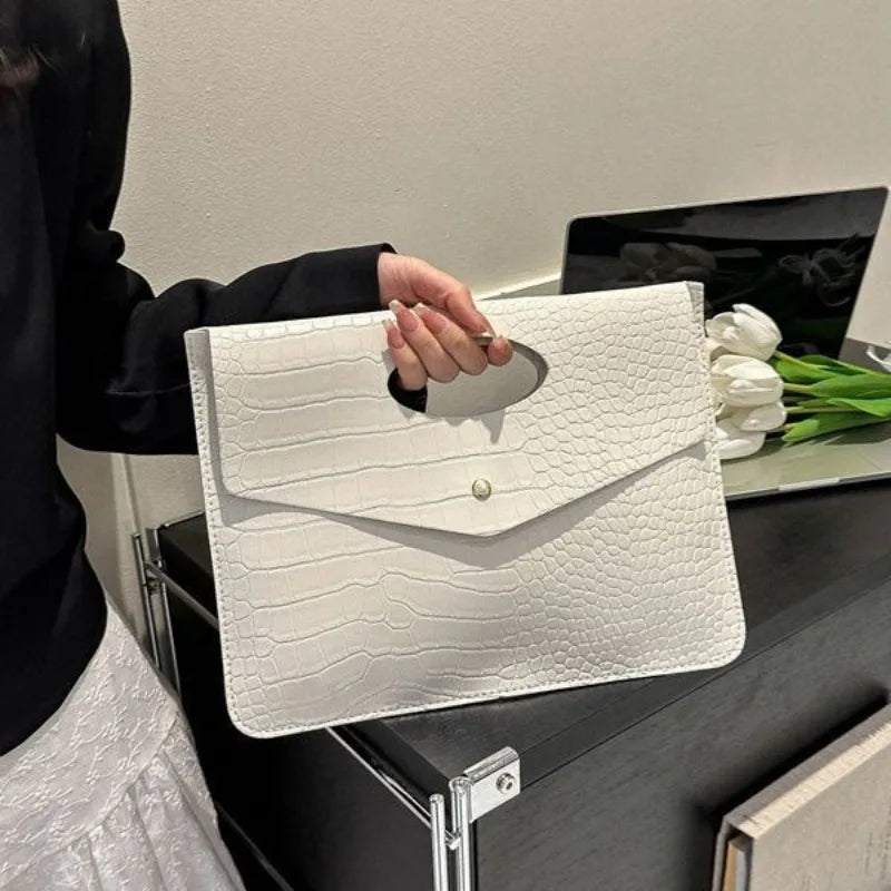 Bold Envelope Evening Clutch in crocodile-textured PU with an oval cutout handhold and flap-style design.
