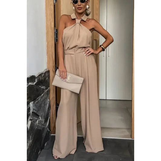 Beige halter neck jumpsuit styled with summer accessories.