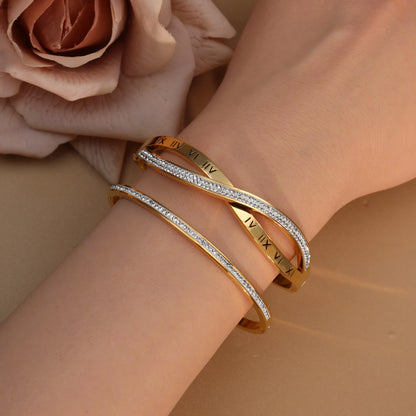 Close-up detail of crystal accents on stainless steel bangle bracelet