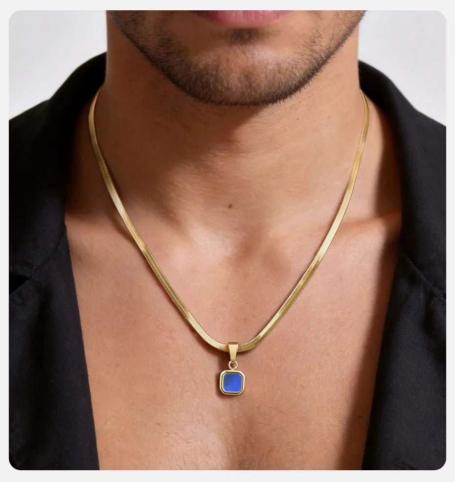 Gold necklace with a blue pendant worn by a person