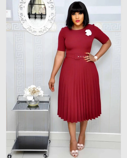 Woman wearing elegant pleated mid-length dress in burgundy