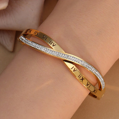 Gold stainless steel bangle with sparkling crystal accents on white background
