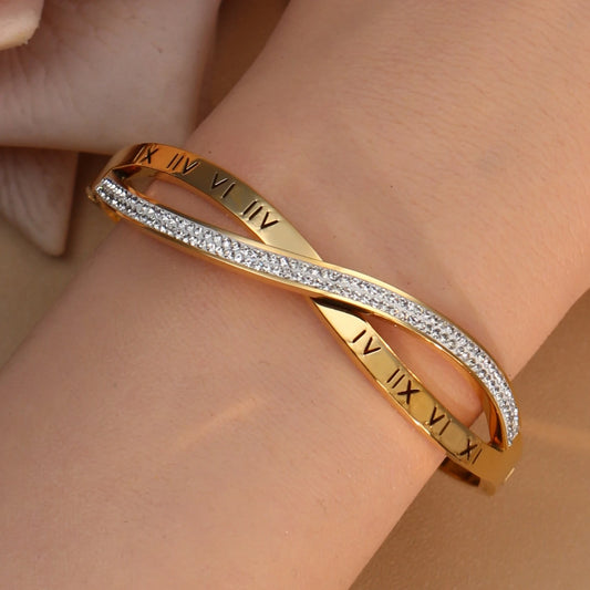 Gold stainless steel bangle with sparkling crystal accents on white background
