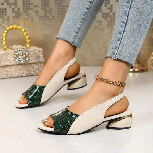 Green and white sandals worn with blue jeans on a light background