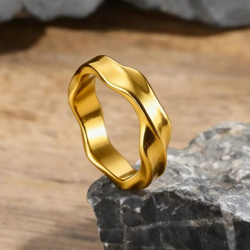 Men's wavy ring in gold finish balanced on grey stone