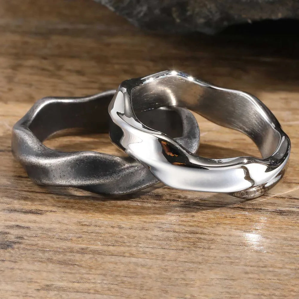 Men's polished silver wave stainless steel ring on wood surface