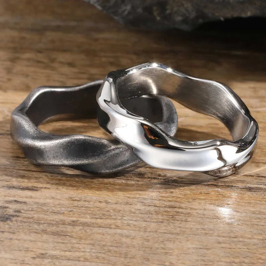 Men's polished silver wave stainless steel ring on wood surface