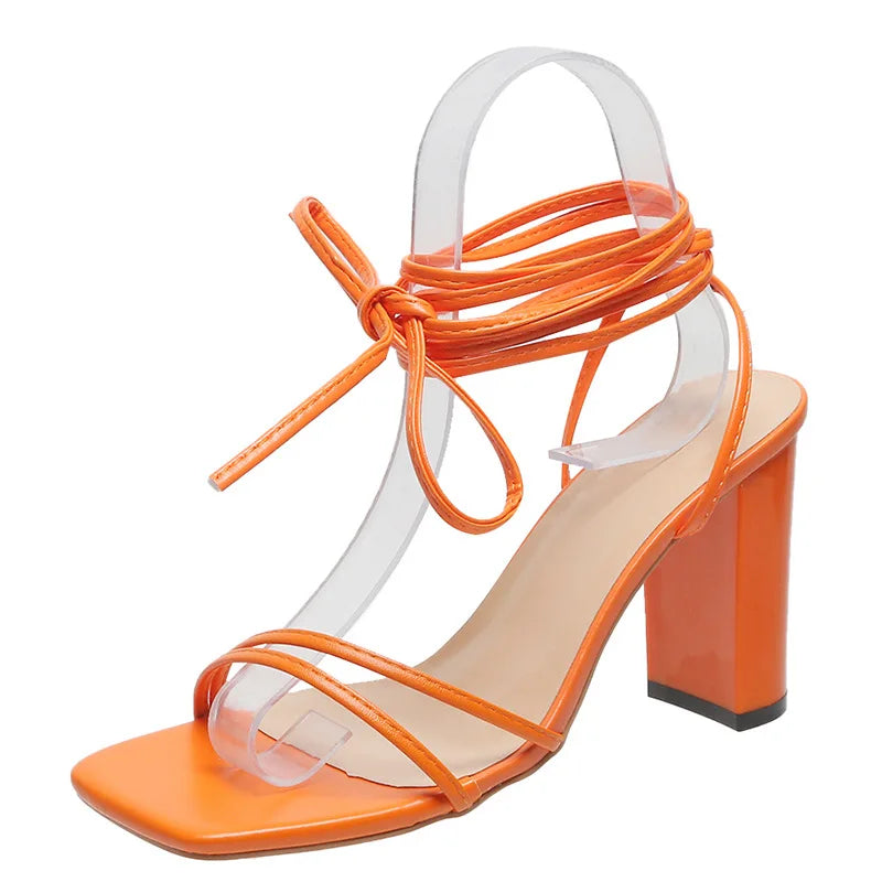 Orange block heel sandals showing square heel and buckle closure