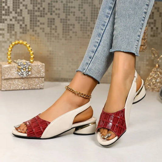 Red and white sandals worn with light blue jeans on a neutral background