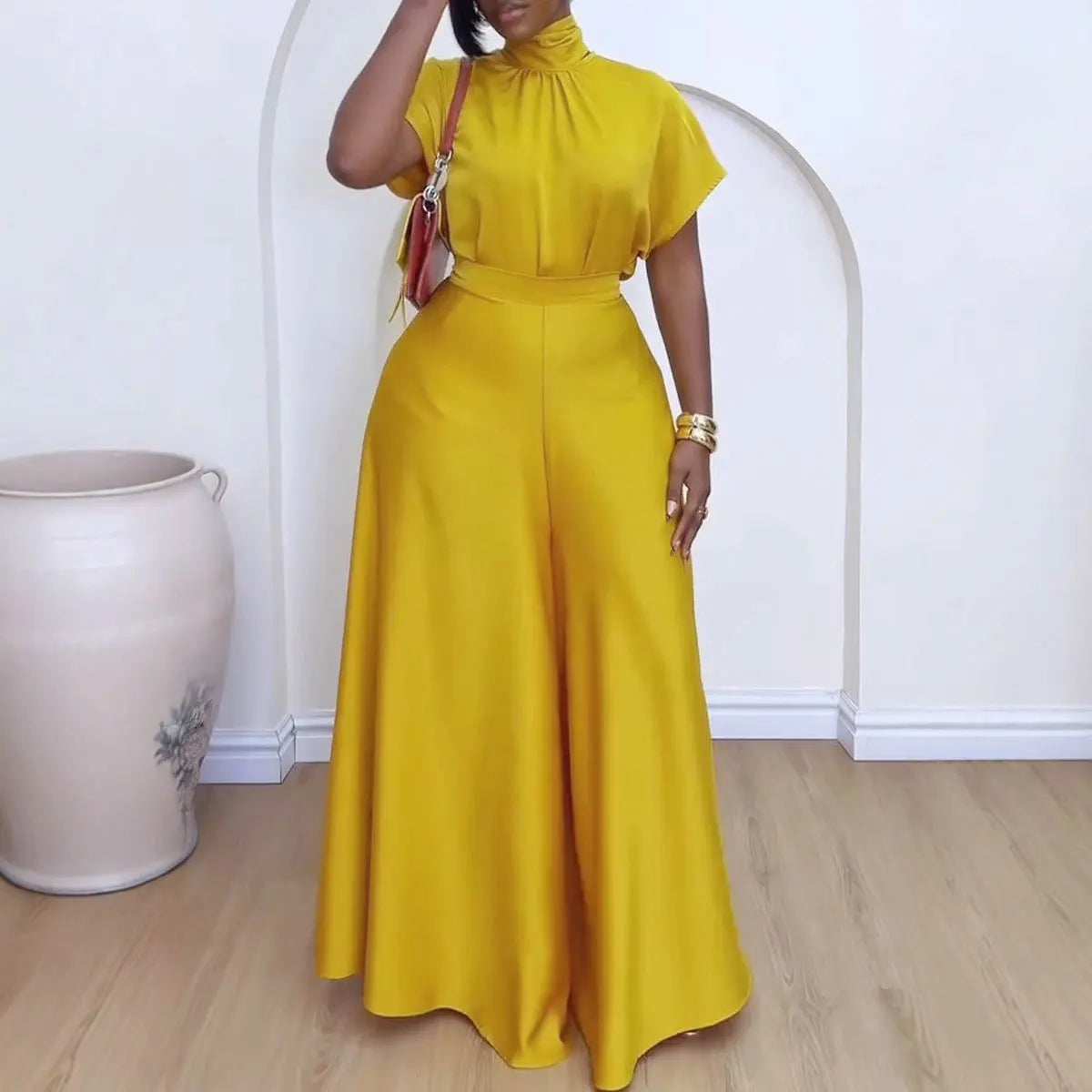 "Woman wearing mustard yellow wide-leg pantsuit with mock neck top and coordinating belt"